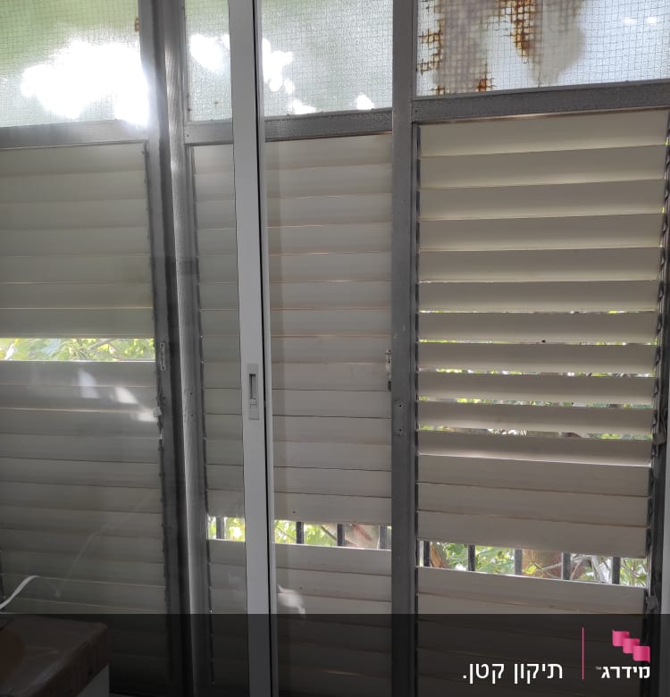 תריסים ישנים עם חלודה על מסגרת מתכת